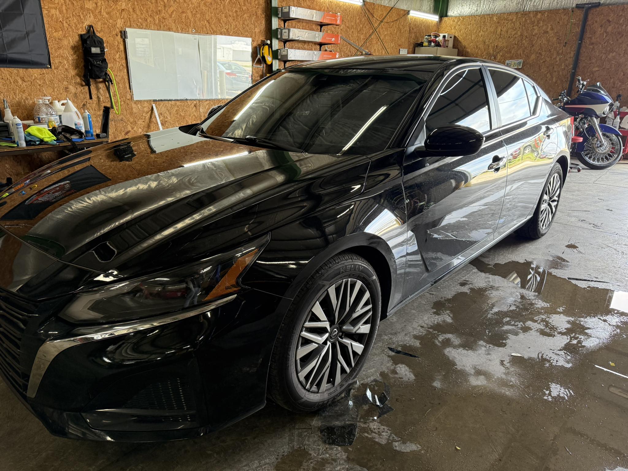 Black Nissan Altima sedan with full Geoshield ceramic window tint installed, photographed in the Bates shop
