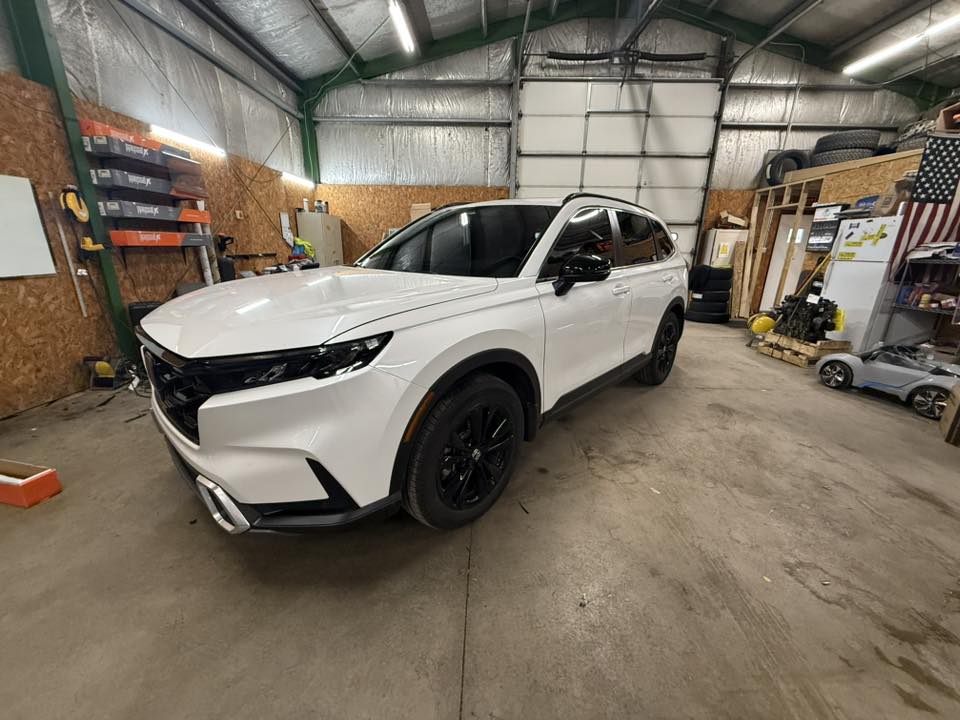 White Honda CR-V with tinted windows in the Bates Window Tint shop